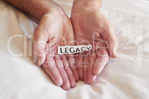 Create a legacy that lasts a lifetime. Cropped shot of a person holding a piece of paper with the word legacy written on it.