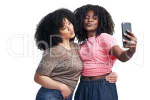 Best friends make the best profile pics. Studio shot of two young women using a smartphone to take selfies against a white background.