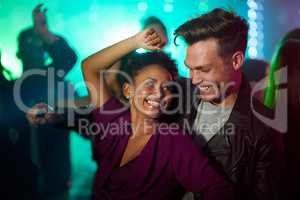 They only have eyes for each other in the club. Shot of a smiling young couple dancing together in a night club.