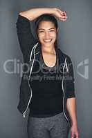 She thrives on exercise. Portrait of a fit young woman in sports clothing posing against a gray background.