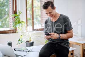 His enthusiasm for work is always running strong. Shot of a young businessman using a cellphone in an office.