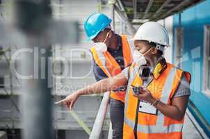 Scaling new heights in the construction sector. Shot of a young woman using a walkie talkie while working with her colleague at a construction site.