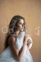 Femininity in focus. Studio shot of an attractive young woman posing against a brown background.