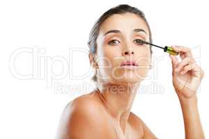 Features that need to be featured. Studio portrait of a beautiful young woman applying mascara against a white background.