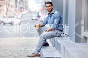 In need of a coffee rush. Shot of a young businessman drinking a cup of coffee in the city.