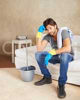 I wont miss a spot. Shot of a young man taking a break from cleaning the house.