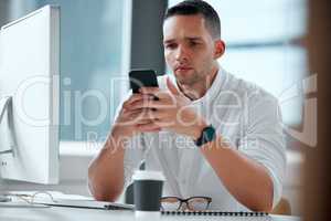 I have to send this message in time. Shot of a young male businessman using his smartphone to send a text.