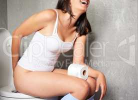 Make sure you wipe thoroughly. Shot of a young woman using the toilet at home.