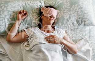 Every girl needs her beauty sleep. Shot of an attractive young woman sleeping with a sleep mask on in her bed at home.