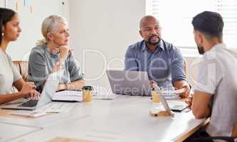 Were open to suggestions. Shot of a group of businesspeople having a meeting in the boardroom.