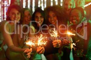 Good friends, good times. Shot of a group of girlfriends having fun with sparklers on a night out.