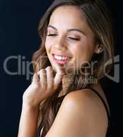 Finding your beautiful bliss. Cropped shot of a beautiful young woman posing against a dark background.