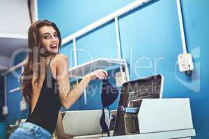 Excuse me while I do my business. Portrait of a attractive young woman doing her washing inside of a laundry room during the day.