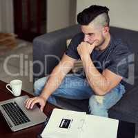 Working extra hours brings him closer to his goal. Shot of a driven young man using his laptop to work from home.