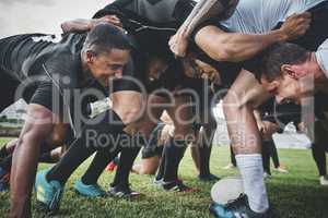 Its a face off. Low angle shot of two young rugby teams competing in a scrum during a rugby match on a field.