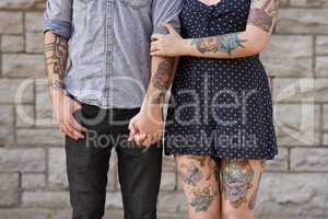 Their bodies are the pages to their love story. Cropped shot of a couple with tattoos on their bodies.