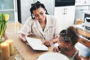 I am not a teacher, but an awakener. Shot of a mother teaching her daughter about the bible at home.