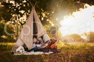 Halt Who goes there. Portrait of two cute little siblings playing together in a teepee outside.