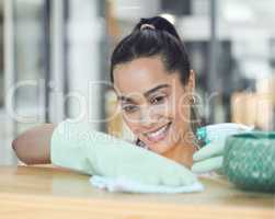 Dust wont win in this house. Shot of a young woman cleaning a surface at home.