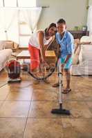 Hes quite helpful around the house. Portrait of a mother and son vacuuming the floor.