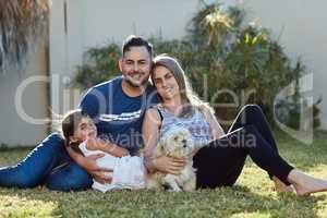 Families should always be surrounded by love. Portrait of a happy family bonding together outside.