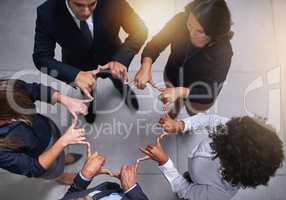 Tapping into their synergy. High angle shot of a group of coworkers making a shape with their hands in the office.