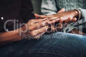 This ring symbolizes my unwavering love and commitment to you. Cropped shot of an unrecognizable man proposing and putting a ring on his girlfriends finger at home.