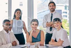 Planning their strategic takeover. Shot of a group of young business people together in their office.