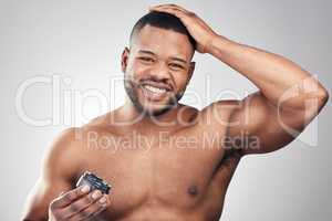 Use products to keep your hair healthy and with good texture. Studio portrait of a handsome young man styling his hair against a white background.