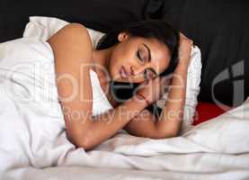 Good quality sleep makes all the difference. Shot of a young woman sleeping peacefully in bed at home.
