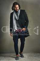 Fashion changes, style endures. Shot of a stylishly dressed man posing against a gray background in the studio.