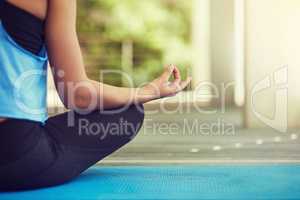 Yoga is the way of life. Cropped shot of a young woman sitting in lotus position.