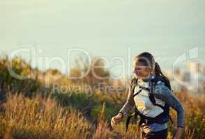 Keep your goal in sight. Shot of a young woman out for a run along a mountain trail.