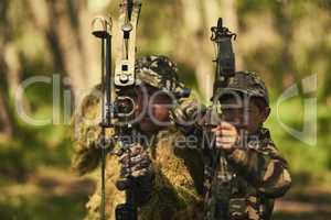 Theyre a deadly duo. Portrait of a father and son in camouflage hunting with bows and arrows in the woods.