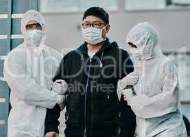 Treatment starts today. Shot of a young man getting taken away by healthcare workers in hazmat suits during an outbreak.
