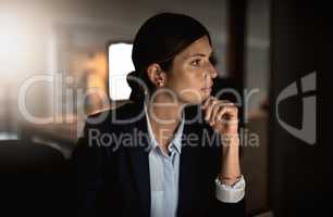 Success is defined by hard work and dedication. Shot of a young businesswoman working online during a late night in a modern office.