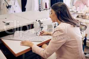 You can depend on her to deliver exceptional work. Shot of a seamstress using a sewing machine while working in her boutique.