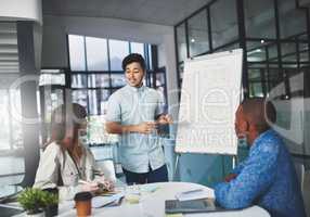 Let me put your mind at ease. Shot of a young businessman using a whiteboard to give a presentation to his colleagues in a boardroom.