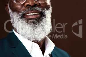 Growing old is a privilege. Cropped shot of a man with grey beard posing against a brown background.