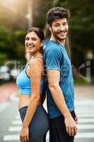 Weve made a pact to maintain our fitness goals together. Portrait of a sporty young couple exercising together outdoors.