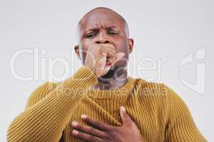 Flu season strikes again. Studio portrait of a handsome young man coughing against a grey background.