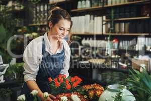 Theres so much beauty and color found in nature. Cropped shot of an attractive young florist arranging flowers inside her plant nursery.