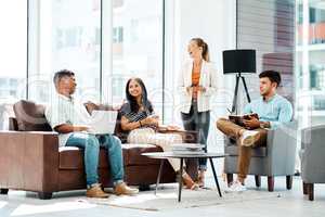 Inspired to keep on producing greatness. Shot of a group of businesspeople having a discussion in an office.