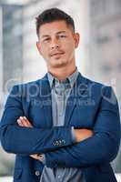 Business challenges dont kill me ambition. Shot of a handsome young businessman standing alone in the office with his arms folded.