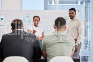 Taking suggestions from their team. Shot of a young businessman and businesswoman giving a presentation to their colleagues in an office.