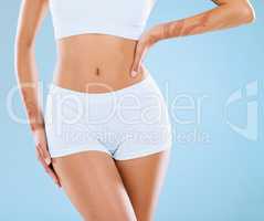Pamper yourself. Shot of an unrecognizable woman posing in her underwear against a blue background.