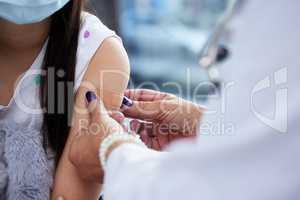 A band-aid for your bravery. Shot of a little girl getting a vaccination in a hospital.