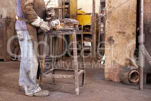 Where industrial meets creative.... A man grinding a piece of metal in a workshop.