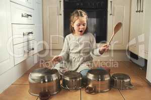This one goes out to all my fans. Shot of a little girl playing drums on a set of pots in the kitchen.