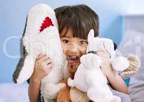 These are all my cuddly friends. Portrait of an adorable little boy playing with his stuffed toys at home.